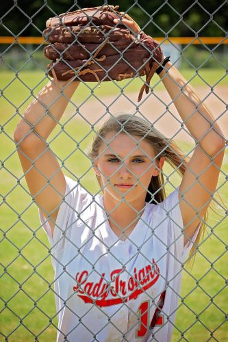 softball girl looking through fence