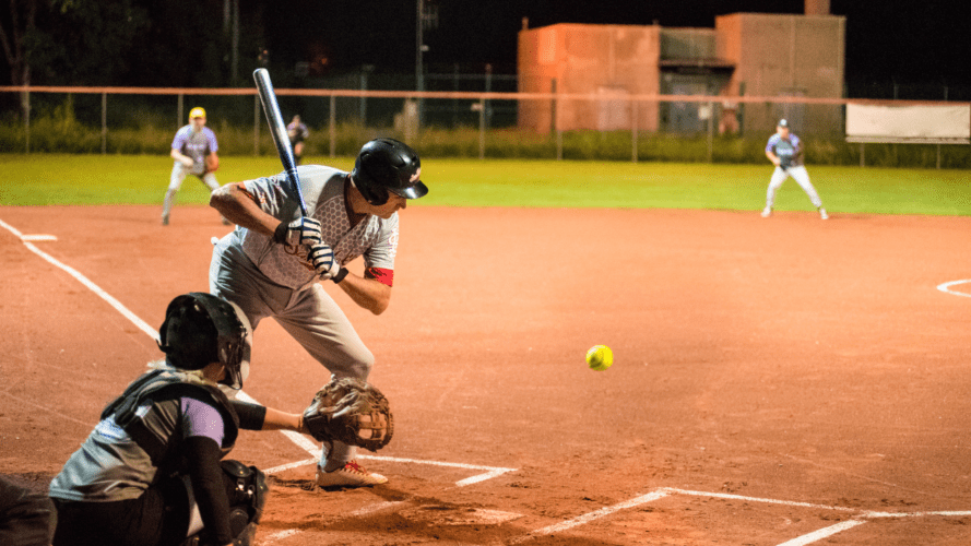 a softball player about to hit the ball