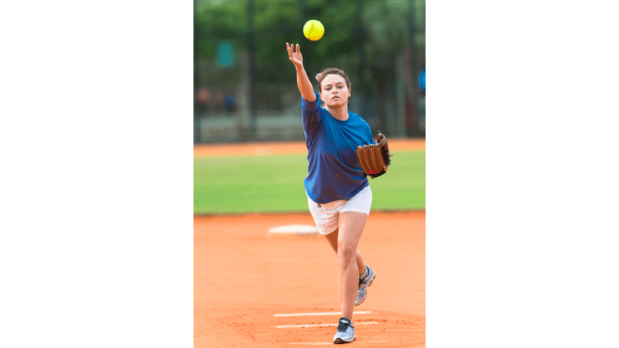 Woman releasing a softball while pitching