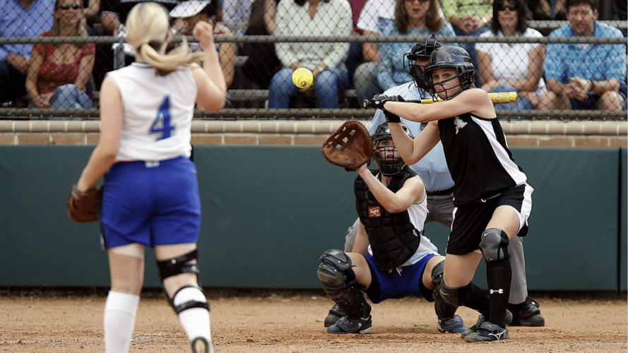 Softball pitch being thrown to a batter during a game
