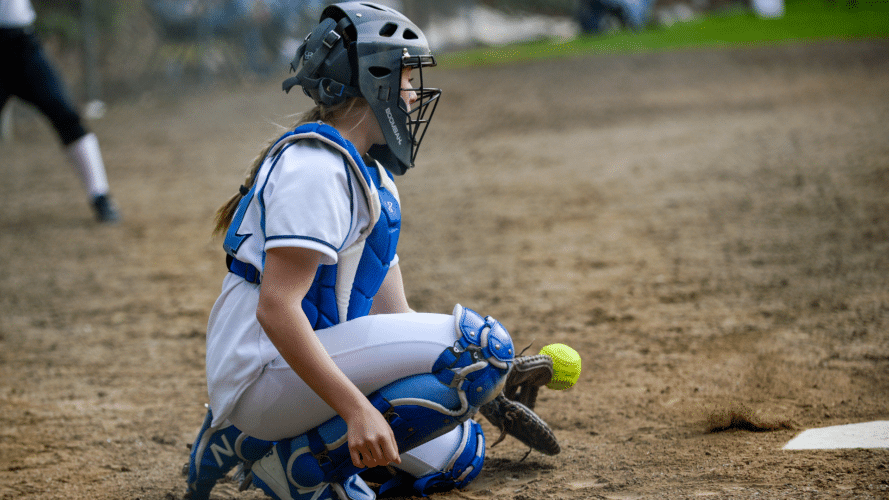 Catcher going down to catch a ball in the dirt.