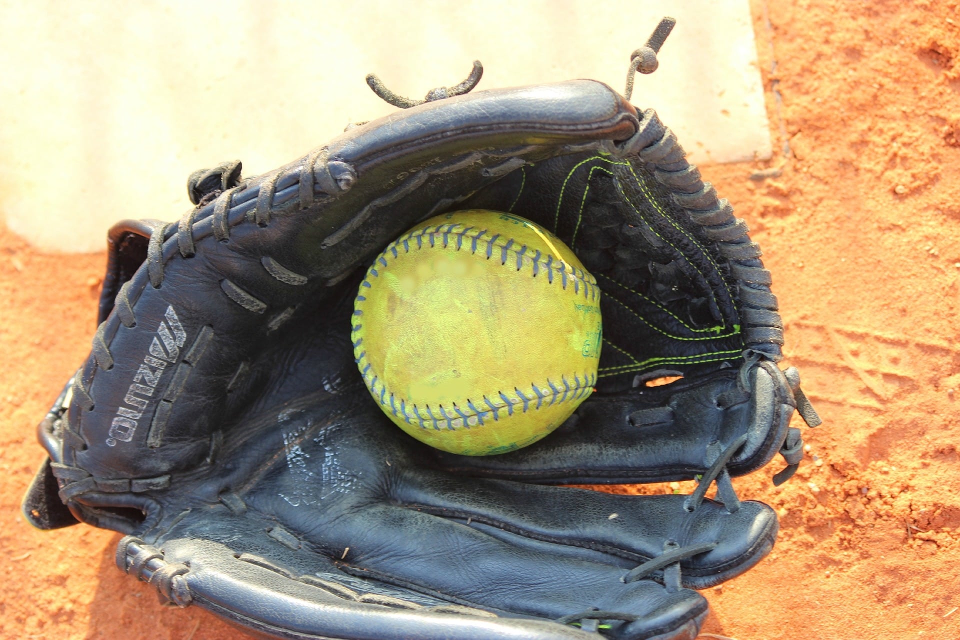 old softball glove by home plate with ball