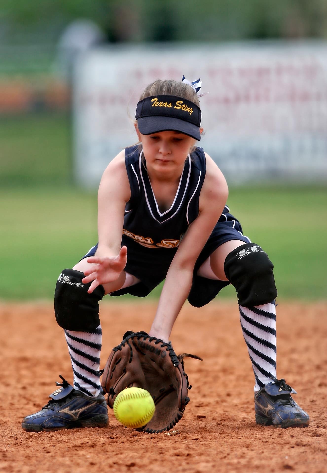 young girl fielding softball