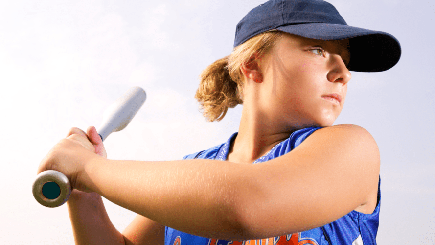 A softball player gazes ahead with intense focus and concentration 