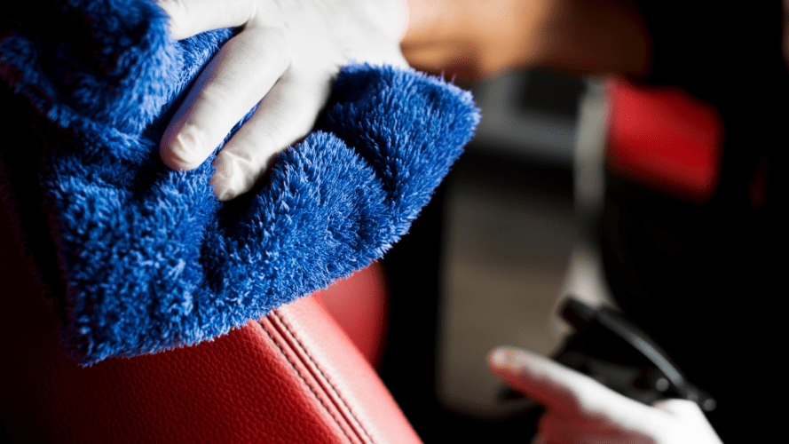 Hands cleaning leather using a cloth towel