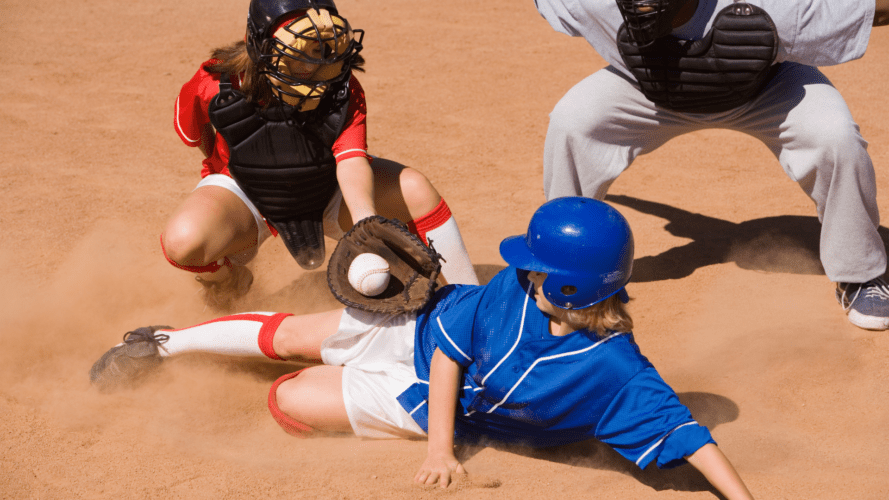 A slide at home plate with a catcher and an umpire