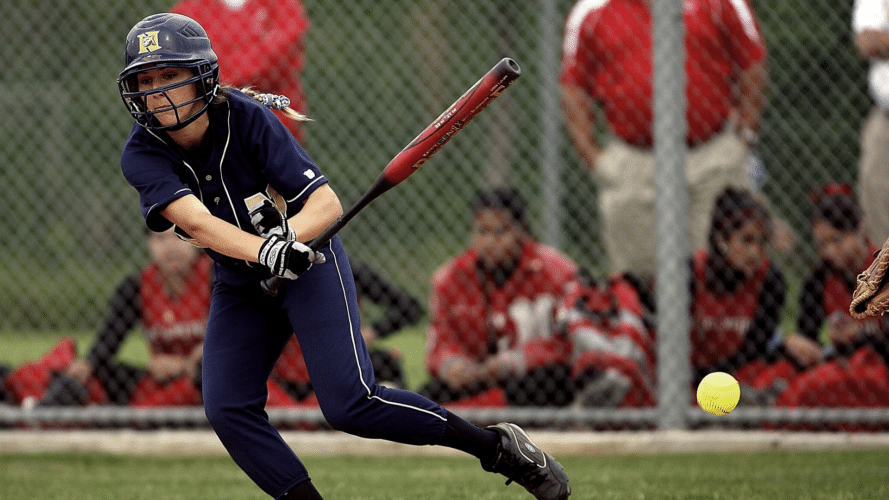 Girl finishing a swing in which she hit a ground ball