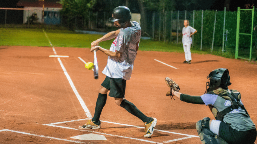Man taking a big swing in a softball game